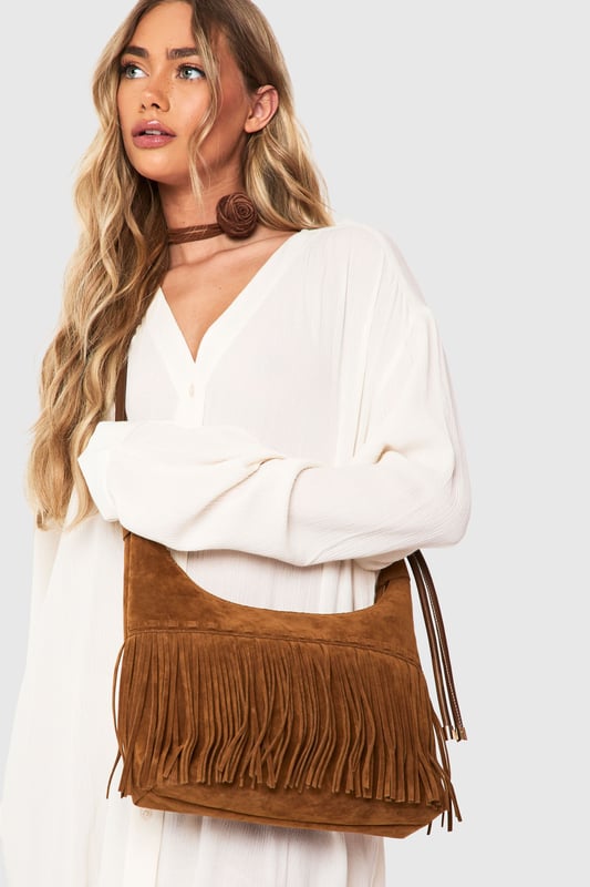 Striking fringe detail along the bottom edge creates movement and texture
        Faux suede finish offers a luxurious tactile experience
        Adjustable shoulder strap for versatile carrying options
        Spacious interior with secure zip closure
        Distinctive stitching detail adds artisanal character
    
    Channel your inner bohemian spirit with this fringed shoulder bag from Boohoo. The cascading fringe detail creates a playful sense of movement that transforms even the simplest outfit into a style statement. Perfect for casual daytime adventures, this bag pairs beautifully with floaty maxi dresses and ankle boots for festival outings, or team with straight-leg jeans and a crisp white blouse for weekend brunches. The adjustable strap allows for comfortable wear across the body or over the shoulder, adapting to your needs throughout the day. Spacious enough for your essentials yet compact enough to remain chic, this bag strikes the perfect balance between fashion and function. The faux suede texture adds a touch of tactile interest that complements both daytime casual and relaxed evening looks.