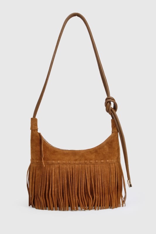 Striking fringe detail along the bottom edge creates movement and texture
        Faux suede finish offers a luxurious tactile experience
        Adjustable shoulder strap for versatile carrying options
        Spacious interior with secure zip closure
        Distinctive stitching detail adds artisanal character
    
    Channel your inner bohemian spirit with this fringed shoulder bag from Boohoo. The cascading fringe detail creates a playful sense of movement that transforms even the simplest outfit into a style statement. Perfect for casual daytime adventures, this bag pairs beautifully with floaty maxi dresses and ankle boots for festival outings, or team with straight-leg jeans and a crisp white blouse for weekend brunches. The adjustable strap allows for comfortable wear across the body or over the shoulder, adapting to your needs throughout the day. Spacious enough for your essentials yet compact enough to remain chic, this bag strikes the perfect balance between fashion and function. The faux suede texture adds a touch of tactile interest that complements both daytime casual and relaxed evening looks.
