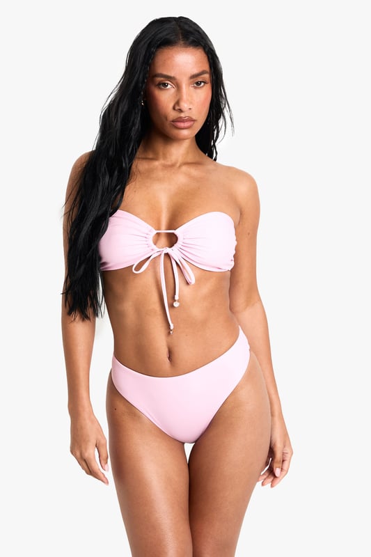 Strapless bandeau top with elegant pearl embellishment at centre front
        Adjustable tie detail for a customised fit and stylish look
        Knitted fabric offers comfortable stretch and shape retention
        Mid-rise bikini bottoms with clean, seamless finish
        Versatile two-piece design perfect for mixing and matching with other swimwear
    
    Make a statement poolside with this chic bandeau bikini set from Boohoo. The striking pearl detail adds a touch of glamour to this otherwise minimalist design, whilst the adjustable tie front allows you to create your perfect fit. The knitted fabric moulds beautifully to your figure, ensuring both comfort and style throughout your holiday. Pair with oversized sunglasses and a flowing kimono for casual beach days, or style with a sheer maxi skirt and metallic sandals for sunset cocktails at the beach bar. This versatile two-piece works brilliantly as a foundation for your holiday wardrobe, easily transitioning from daytime sunbathing to evening promenade strolls with just a few accessory changes.