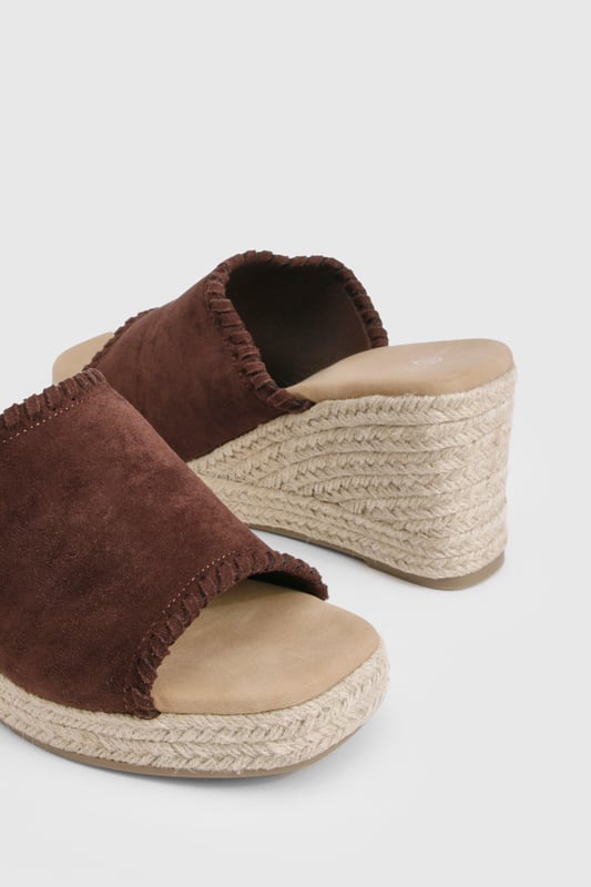 Chic suede mule espadrilles with comfortable mid-height wedge heel (5-6.5cm)
        Open toe design perfect for showcasing summer pedicures
        Traditional rope-wrapped wedge sole for authentic Mediterranean appeal
        Slip-on style for effortless wear and convenience
        Cushioned footbed providing all-day comfort and support
    
    These versatile Wildleder Espadrilles from Boohoo blend timeless Mediterranean charm with contemporary styling. The classic rope-wrapped wedge creates a flattering silhouette whilst maintaining walkable comfort with its mid-height design. Perfect for casual daytime events, these mules pair beautifully with flowing midi skirts and summer dresses as shown, or style with cropped trousers and a linen blouse for relaxed weekend brunches. The suede finish adds a touch of luxury to your everyday wardrobe, whilst the open-toe silhouette keeps your look fresh and seasonal. Complement with natural accessories like the woven handbag featured for a coordinated summer ensemble. These espadrilles transition effortlessly from family gatherings to beachside restaurants, offering both style and practicality for the fashion-forward woman who values versatility in her footwear collection.