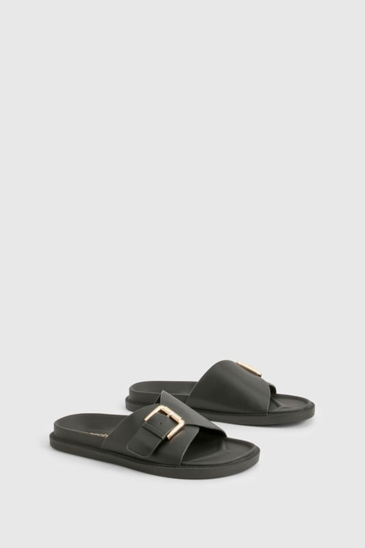 Sleek single-strap design with adjustable metal buckle detail
        Flat sole with comfortable 0-2cm heel height for all-day wear
        Smooth PU construction offering durability and easy maintenance
        Wide foot strap with contemporary minimalist aesthetic
        Slip-on style for effortless wearing and removal
    
    These versatile buckled sandals are the perfect addition to your casual wardrobe. The minimalist design pairs brilliantly with frayed denim as shown, but works equally well with floaty summer dresses or tailored shorts. The adjustable buckle ensures a customised fit while maintaining the clean, unfussy silhouette that makes these sandals so adaptable. Ideal for city breaks where comfort meets style, they'll take you from daytime sightseeing to casual evening meals without missing a beat. The flat profile offers stability for long walks, whilst the simple design ensures they'll complement virtually any outfit in your holiday collection. Perfect for family gatherings, weekend brunches or casual shopping trips when you need footwear that combines practicality with Boohoo's signature contemporary flair.