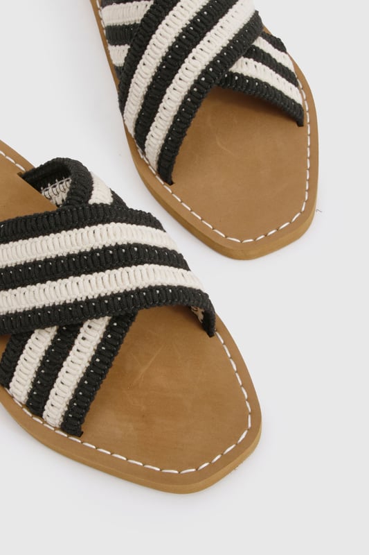 Distinctive crochet cross-over straps with bold stripe pattern
        Comfortable flat design with heel height between 0-2cm
        Cushioned footbed with contrast stitching detail
        Durable non-slip sole perfect for everyday wear
        Easy slip-on style for effortless summer dressing
    
    These crochet cross-over sandals bring a touch of artisanal charm to your summer wardrobe. The textured crochet finish creates visual interest while the contrasting stripe pattern adds a contemporary twist to a classic silhouette. Style them with a flowing maxi dress for a relaxed beach day, or pair with cropped trousers and a linen shirt for casual weekend brunches. The flat design ensures all-day comfort whether you're strolling through city streets or enjoying a coastal getaway. For festival season, match with denim shorts and a graphic tee, or dress them up with a breezy midi skirt for garden parties. Their versatility makes them an essential addition to your holiday packing list - perfect for transitioning from poolside lounging to impromptu evening walks along the promenade.