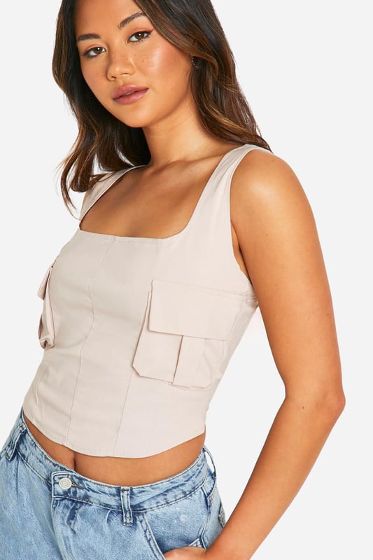 Sleek utility-inspired korsett top
        Flattering sweetheart neckline
        Trendy square straps for a modern look
        Functional pocket detail adds edge
        Figure-hugging bengaline fabric for comfort and style
    
    Make a statement with this chic utility-korsett top, perfect for the fashion-forward trendsetter. The sweetheart neckline and square straps create a flattering silhouette, while the pocket detail adds a touch of edgy charm. Pair this versatile piece with high-waisted wide-leg jeans and strappy heels for a night out with the girls. For a more casual look, throw on a leather jacket and trainers. The bengaline fabric ensures a comfortable fit that hugs your curves in all the right places. Whether you're hitting the club or meeting friends for drinks, this top is sure to turn heads and keep you looking fabulous all night long. Customise your look with statement jewellery and a clutch bag to complete your ensemble.