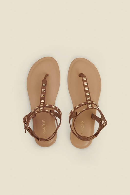 Consider your outfit elevated Crafted from the softest tan leather Timeless toe post silhouette Elevated with luxe gold studs Statement double strap design for a secure fit We're styling them with a white dress