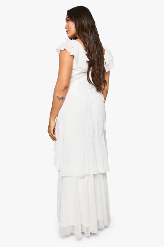 Textured dobby chiffon fabric with delicate dotted pattern throughout
        Elegant tiered maxi design with flowing layers for graceful movement
        Feminine cap sleeves with subtle ruffle detailing
        Flattering scoop neckline frames the dcolletage beautifully
        Fully lined for comfort and coverage with a floaty silhouette
    
    This enchanting tiered maxi dress showcases the beauty of textured dobby chiffon in a design that flatters every curve. The thoughtfully crafted layers cascade elegantly to the floor, creating a romantic silhouette perfect for special occasions. Style with metallic strappy sandals and a structured clutch as shown for formal events, or dress down with delicate flat sandals for garden parties. The versatile design works brilliantly for summer weddings, graduation ceremonies or race day events. The soft cap sleeves offer just the right amount of coverage whilst maintaining an ethereal quality that moves beautifully with every step. Complete your ensemble with understated jewellery to maintain the dress's graceful presence as the focal point of your look.