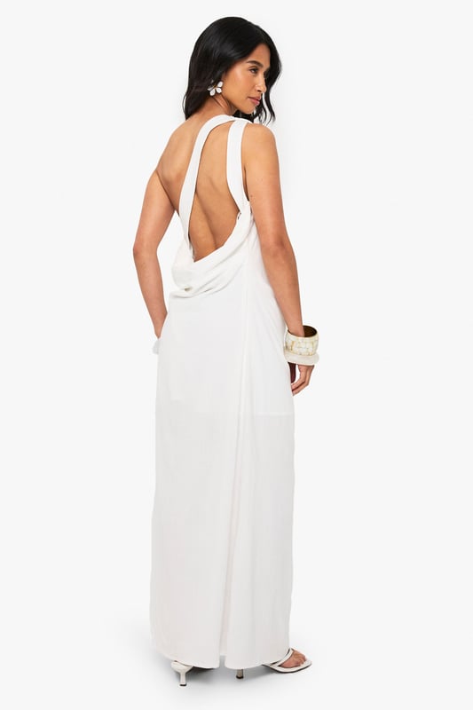 Striking one-shoulder design with elegant draping detail
        Flowing maxi length with side split for effortless movement
        Dramatic open back feature adds a sultry touch
        Linen-look fabric offers a lightweight, textured finish
        Petite fit designed specifically for smaller frames
    
    This captivating draped maxi dress combines Grecian-inspired elegance with contemporary flair. The asymmetric one-shoulder neckline creates a striking silhouette, while the flowing fabric cascades beautifully to the floor with a side split that allows for graceful movement. Perfect for evening soires, pair with strappy heels and statement bangles as shown for a sophisticated nightlife look. The open back detail adds an unexpected twist to this otherwise classic design. Versatile enough for upscale cocktail events or summer parties, this dress can be styled with metallic accessories for glamorous occasions or dressed down with flat sandals for more casual gatherings. The linen-look texture adds dimension and interest to this Boohoo showstopper that's sure to turn heads on your next night out.
