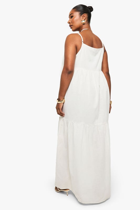 Tiered maxi design with flowing silhouette for effortless movement
        Distinctive strappy neckline with decorative front detail for added interest
        Lightweight linen-look fabric perfect for warm-weather comfort
        Relaxed fit with generous cut through body for all-day ease
        Versatile floor-length style suitable for various casual occasions
    
    This breezy tiered maxi dress captures carefree summer style with its flowing silhouette and distinctive strappy neckline. The decorative front detail adds a touch of bohemian charm, while the lightweight linen-look fabric ensures comfort during warmer days. Style with flat sandals and a mini handbag as shown for daytime gatherings, or customise with layered gold jewellery and espadrilles for alfresco dining. The relaxed fit makes this Boohoo piece ideal for family barbecues, beach outings, or casual weekend brunches. Its neutral versatility allows for endless accessorising options - try adding a denim jacket for cooler evenings or a wide-brimmed hat for garden parties. This plus-size dress combines effortless style with practical comfort for your everyday summer wardrobe.