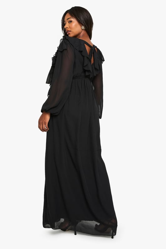 Flowing chiffon maxi-skater dress with dramatic ruffle detailing across the bodice
        Elegant V-neckline complemented by long, billowy sleeves for a romantic silhouette
        Flattering empire waistline that creates a feminine shape
        Striking open back design with delicate tie fastening
        Floor-sweeping length with gentle flare for graceful movement
    
    Make a captivating entrance at your next formal occasion in this enchanting chiffon maxi dress. The cascading ruffles create a sense of drama whilst the flowing skater silhouette ensures comfort throughout your event. Style with strappy heels and a compact clutch as seen on our model for a sophisticated evening ensemble. Perfect for weddings, formal dinners or graduation ceremonies, this dress offers versatility without compromising on elegance. The V-neckline frames the dcolletage beautifully, whilst the open back detail adds an unexpected twist to this otherwise classic piece. For cooler evenings, layer with a tailored blazer or delicate wrap to maintain the refined aesthetic whilst staying comfortable as you dance the night away.