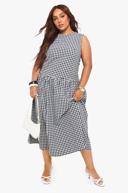 Textured gingham midi dress with a flattering smocked design
        Sleeveless silhouette with a modest round neckline
        Practical side pockets for everyday convenience
        Gathered skirt detail creates a feminine, flowing shape
        Versatile midi length perfect for various seasonal styling
    
    This charming gingham midi dress combines timeless pattern with contemporary design. The smocked detailing creates a flattering silhouette that gently defines the waist before flowing into a beautifully gathered skirt. Style with white kitten heels and a small handbag for family gatherings or weekend brunches. For cooler days, layer with a cropped denim jacket and trainers for an effortlessly casual look. The practical side pockets add functionality to fashion, while the versatile midi length works beautifully across seasons. Perfect for garden parties, casual outings or relaxed office environments, this Boohoo dress offers the ideal balance of comfort and style for the fashion-forward woman who values both trend and wearability.
