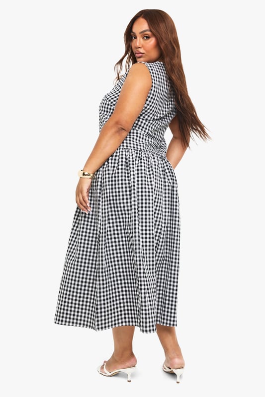 Textured gingham midi dress with a flattering smocked design
        Sleeveless silhouette with a modest round neckline
        Practical side pockets for everyday convenience
        Gathered skirt detail creates a feminine, flowing shape
        Versatile midi length perfect for various seasonal styling
    
    This charming gingham midi dress combines timeless pattern with contemporary design. The smocked detailing creates a flattering silhouette that gently defines the waist before flowing into a beautifully gathered skirt. Style with white kitten heels and a small handbag for family gatherings or weekend brunches. For cooler days, layer with a cropped denim jacket and trainers for an effortlessly casual look. The practical side pockets add functionality to fashion, while the versatile midi length works beautifully across seasons. Perfect for garden parties, casual outings or relaxed office environments, this Boohoo dress offers the ideal balance of comfort and style for the fashion-forward woman who values both trend and wearability.