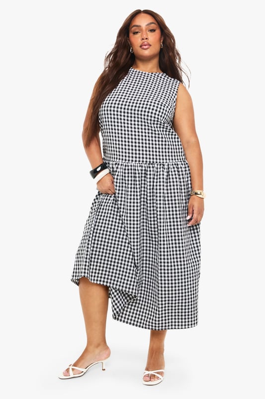 Textured gingham midi dress with a flattering smocked design
        Sleeveless silhouette with a modest round neckline
        Practical side pockets for everyday convenience
        Gathered skirt detail creates a feminine, flowing shape
        Versatile midi length perfect for various seasonal styling
    
    This charming gingham midi dress combines timeless pattern with contemporary design. The smocked detailing creates a flattering silhouette that gently defines the waist before flowing into a beautifully gathered skirt. Style with white kitten heels and a small handbag for family gatherings or weekend brunches. For cooler days, layer with a cropped denim jacket and trainers for an effortlessly casual look. The practical side pockets add functionality to fashion, while the versatile midi length works beautifully across seasons. Perfect for garden parties, casual outings or relaxed office environments, this Boohoo dress offers the ideal balance of comfort and style for the fashion-forward woman who values both trend and wearability.