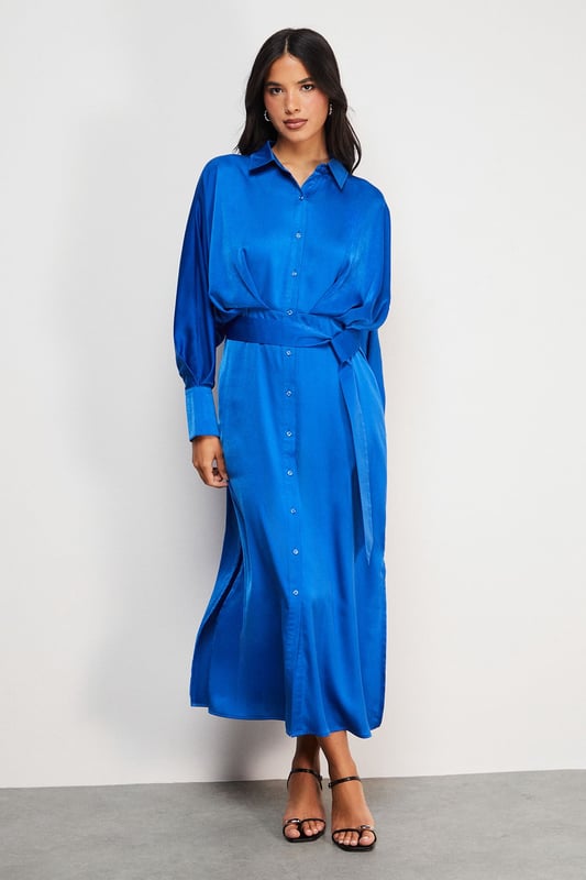 Striking batwing sleeves for a dramatic silhouette
        Elegant midi length with a daring side split
        Collared neckline adds a touch of sophistication
        Button-down front for versatile styling options
        Cinched waist design creates a flattering shape
    
    This satin shirt dress from Warehouse is a versatile piece that effortlessly transitions from day to night. The batwing sleeves create a bold, contemporary look, while the midi length with a side split adds a hint of allure. Perfect for confident women who appreciate edgy yet feminine styles, this dress can be styled for various casual occasions. For a chic daytime ensemble, pair it with ankle boots and a crossbody bag for a family lunch or weekend outing. Layer with a leather jacket for an edgier look when meeting friends for coffee. The button-down front allows for customisable coverage, making it suitable for different settings. Accessorise with statement earrings and a sleek updo for an evening dinner date. The dress's fluid silhouette and rich texture make it a standout piece in any wardrobe, ideal for those who want to make a subtle yet impactful fashion statement.