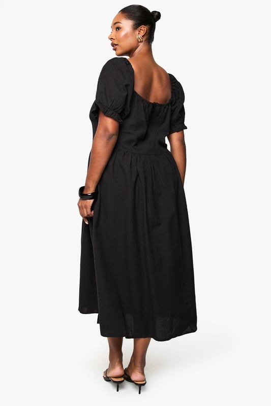 Crafted from breathable linen-look fabric, perfect for warm-weather comfort
        Feminine puff sleeves with delicate gathered detailing at the cuffs
        Flattering scoop neckline that frames the dcolletage beautifully
        Midi-length silhouette with a relaxed, flowing skirt that skims the body
        Gathered waist design creates a defined silhouette with effortless movement
    
    This versatile plus-size midi dress combines casual charm with timeless elegance. The linen-look fabric offers a natural texture that works brilliantly for daytime gatherings whilst maintaining a polished appearance. Style with flat sandals and a woven tote bag as shown for farmers' markets or weekend brunches. For garden parties, pair with espadrille wedges and statement earrings. The gathered waistline creates a flattering shape that works beautifully across body types, while the puff sleeves add a contemporary touch to this classic silhouette. This Boohoo dress transitions seamlessly from casual daywear to relaxed evening occasions - simply swap your accessories and add a denim jacket for cooler evenings. Perfect for holidays, family gatherings or casual Friday workwear when styled with a tailored blazer.