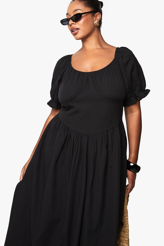 Crafted from breathable linen-look fabric, perfect for warm-weather comfort
        Feminine puff sleeves with delicate gathered detailing at the cuffs
        Flattering scoop neckline that frames the dcolletage beautifully
        Midi-length silhouette with a relaxed, flowing skirt that skims the body
        Gathered waist design creates a defined silhouette with effortless movement
    
    This versatile plus-size midi dress combines casual charm with timeless elegance. The linen-look fabric offers a natural texture that works brilliantly for daytime gatherings whilst maintaining a polished appearance. Style with flat sandals and a woven tote bag as shown for farmers' markets or weekend brunches. For garden parties, pair with espadrille wedges and statement earrings. The gathered waistline creates a flattering shape that works beautifully across body types, while the puff sleeves add a contemporary touch to this classic silhouette. This Boohoo dress transitions seamlessly from casual daywear to relaxed evening occasions - simply swap your accessories and add a denim jacket for cooler evenings. Perfect for holidays, family gatherings or casual Friday workwear when styled with a tailored blazer.