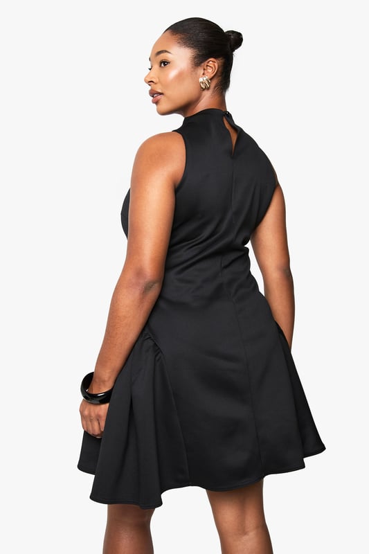 Structured scuba fabric creates a flattering silhouette that holds its shape beautifully
        High neckline with elegant mock-neck design adds sophistication
        Sleeveless cut showcases arms whilst maintaining a refined look
        Voluminous skater skirt creates dramatic movement and playful flair
        Back fastening ensures a smooth, streamlined front appearance
    
    Make a statement after dark in this structured skater dress that combines contemporary design with classic appeal. The mock-neck silhouette and sleeveless cut create a balanced look that's both modern and timeless, whilst the voluminous skirt adds dramatic flair to your night-out ensemble. Style with strappy heels and a compact clutch for drinks with the girls, or dress it up with statement jewellery and a bold cuff bracelet for club nights. The scuba fabric offers just the right amount of structure to maintain the dress's distinctive shape throughout the evening. This versatile piece transitions effortlessly from casual cocktails to more upscale venues-simply switch up your accessories to match the occasion. A true wardrobe hero for the fashion-forward woman who values both style and comfort for her night-time adventures.