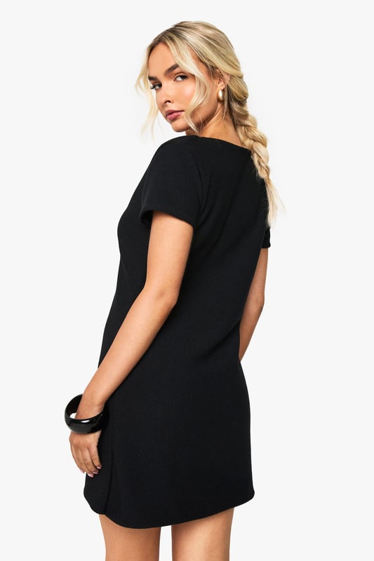 Cap Sleeve Gold Button V Neck Shift Dress Flattering V-neckline design with short sleeves for effortless style
Distinctive gold-tone button detailing down the front creates visual interest
Figure-enhancing ribbed fabric that contours to your silhouette
Versatile mini length perfect for showcasing your favourite footwear
Structured yet comfortable fit that maintains its shape throughout the night
Make a statement on your next night out with this chic button-through dress from Boohoo. The ribbed texture adds dimension whilst the V-neckline frames your dcolletage beautifully. Style with strappy heels and statement jewellery as seen on our model for a complete look that transitions seamlessly from drinks to dancing. The gold-tone buttons add a touch of glamour to this otherwise minimalist piece. For cooler evenings, layer with a cropped jacket and accessorise with a compact handbag. This versatile dress works brilliantly for impromptu drinks with friends or planned nights at the club - simply customise your accessories to suit the occasion.
