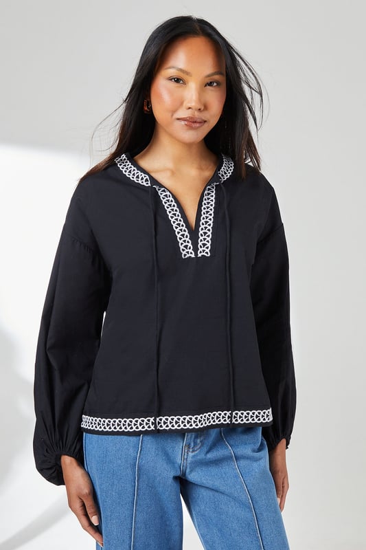 Embroidered Detail Blouse Distinctive embroidered trim along the V-neckline and hem adds artisanal character
Relaxed regular fit with voluminous balloon sleeves for contemporary silhouette
Crafted from pure cotton for breathable comfort throughout the day
Split V-neckline with subtle tie detail creates a flattering frame
Versatile woven design that transitions effortlessly from casual to smart-casual occasions
This Principles embroidered detail blouse combines timeless design with modern styling. The striking geometric embroidery creates a beautiful contrast against the woven fabric, whilst the relaxed silhouette ensures all-day comfort without compromising on style. Pair with wide-leg denim and flat sandals as seen on our model for a relaxed weekend look, perfect for farmers' markets or casual brunches. For a more polished daytime ensemble, try tucking the front into tailored trousers and adding a structured tote. The balloon sleeves add a touch of drama to this otherwise understated piece, making it ideal for family gatherings or informal work settings. This versatile blouse works beautifully with both light and dark bottoms, offering countless styling possibilities throughout the seasons.