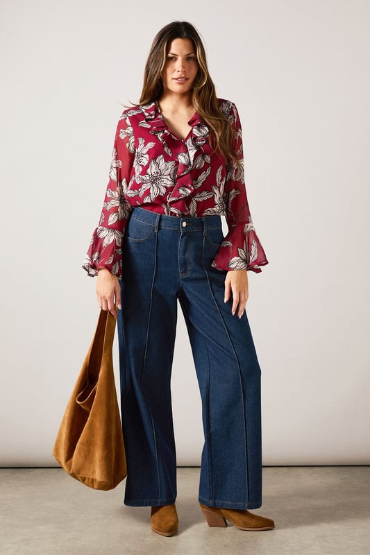 Elegant V-neckline with cascading ruffle detail for a feminine touch
        Striking floral print throughout for a sophisticated daytime look
        Graceful bell sleeves with flared cuffs adding movement and charm
        Lightweight woven fabric offering comfort and easy wearability
        Versatile silhouette that can be styled tucked in or worn loose
    
    This Wallis blouse combines sophistication with effortless style through its beautiful ruffle detailing and eye-catching floral pattern. The flattering V-neckline frames the dcolletage beautifully, while the statement bell sleeves create a graceful silhouette that moves with you. Perfect for daytime occasions, style this versatile piece with wide-leg denim trousers as shown for a casual family lunch, or tuck into a tailored skirt for garden parties. The lightweight fabric ensures all-day comfort without compromising on style. Accessorise with simple gold-toned jewellery and a slouchy tote bag for a complete look that transitions seamlessly from shopping trips to casual gatherings. This blouse offers the glamour and sophistication Wallis is known for while maintaining practicality for everyday wear.