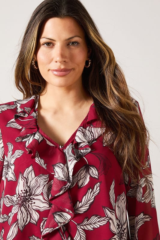 Elegant V-neckline with cascading ruffle detail for a feminine touch
        Striking floral print throughout for a sophisticated daytime look
        Graceful bell sleeves with flared cuffs adding movement and charm
        Lightweight woven fabric offering comfort and easy wearability
        Versatile silhouette that can be styled tucked in or worn loose
    
    This Wallis blouse combines sophistication with effortless style through its beautiful ruffle detailing and eye-catching floral pattern. The flattering V-neckline frames the dcolletage beautifully, while the statement bell sleeves create a graceful silhouette that moves with you. Perfect for daytime occasions, style this versatile piece with wide-leg denim trousers as shown for a casual family lunch, or tuck into a tailored skirt for garden parties. The lightweight fabric ensures all-day comfort without compromising on style. Accessorise with simple gold-toned jewellery and a slouchy tote bag for a complete look that transitions seamlessly from shopping trips to casual gatherings. This blouse offers the glamour and sophistication Wallis is known for while maintaining practicality for everyday wear.