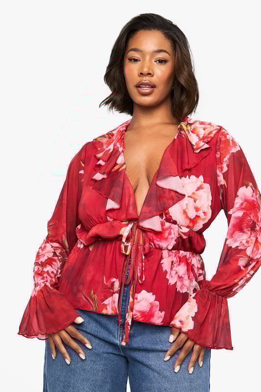 Floral peplum top with feminine ruffle detailing for added dimension
        Plunging V-neckline with cascading ruffle trim that frames the dcolletage
        Flattering elasticated waist with front tie closure for an adjustable fit
        Statement bell sleeves with pleated cuffs for a dramatic silhouette
        Lightweight jersey fabric that drapes beautifully for all-day comfort
    
    Make a striking impression with this boohoo floral peplum top that combines romantic details with contemporary styling. The ruffle-trimmed V-neckline creates a flattering frame for your dcolletage, while the peplum silhouette cinches at the waist before gently flaring out to complement your curves. Style with wide-leg denim jeans as shown for a balanced casual look, or dress it up with tailored trousers and heels for evening drinks. The statement bell sleeves add a touch of drama to this versatile piece, making it perfect for family gatherings or weekend brunches. Complete your ensemble with minimal jewellery and a small handbag to let the top's beautiful design take centre stage. This top effortlessly transitions from day to night, offering both comfort and style for the fashion-forward woman.