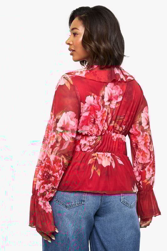 Floral peplum top with feminine ruffle detailing for added dimension
        Plunging V-neckline with cascading ruffle trim that frames the dcolletage
        Flattering elasticated waist with front tie closure for an adjustable fit
        Statement bell sleeves with pleated cuffs for a dramatic silhouette
        Lightweight jersey fabric that drapes beautifully for all-day comfort
    
    Make a striking impression with this boohoo floral peplum top that combines romantic details with contemporary styling. The ruffle-trimmed V-neckline creates a flattering frame for your dcolletage, while the peplum silhouette cinches at the waist before gently flaring out to complement your curves. Style with wide-leg denim jeans as shown for a balanced casual look, or dress it up with tailored trousers and heels for evening drinks. The statement bell sleeves add a touch of drama to this versatile piece, making it perfect for family gatherings or weekend brunches. Complete your ensemble with minimal jewellery and a small handbag to let the top's beautiful design take centre stage. This top effortlessly transitions from day to night, offering both comfort and style for the fashion-forward woman.