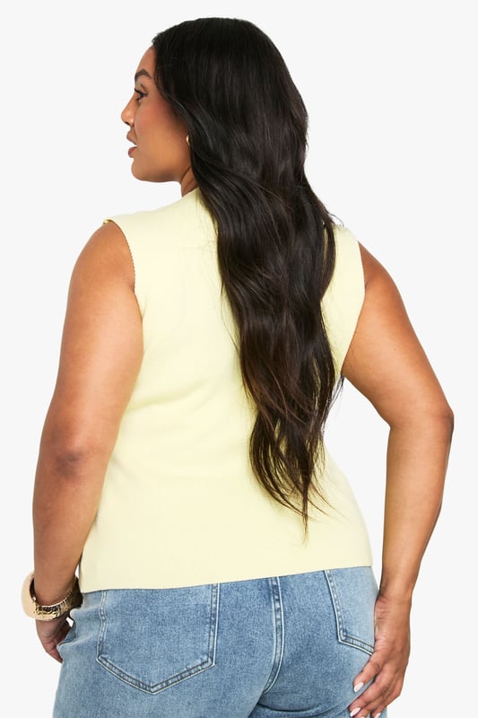 Asymmetrical knitted waistcoat with distinctive gold-tone button detailing
        Sleeveless design with a flattering V-neckline
        Structured silhouette that creates a contemporary profile
        Versatile length that works perfectly with high-waisted bottoms
        Inclusive plus size fit designed to complement your curves
    
    This striking asymmetrical waistcoat brings a modern twist to your casual collection. The knitted fabric offers just the right amount of structure whilst maintaining comfort for all-day wear. Style with your favourite high-waisted jeans as shown for a relaxed daytime look, or dress up with tailored wide-leg trousers for more polished occasions. The gold-tone buttons add a touch of sophistication that catches the light beautifully. Perfect for family gatherings or brunches with friends, this Boohoo piece transitions effortlessly from day to evening - simply swap your trainers for block heels and add statement jewellery. The versatile design allows for layering in cooler months or wearing alone as a statement piece when temperatures rise.