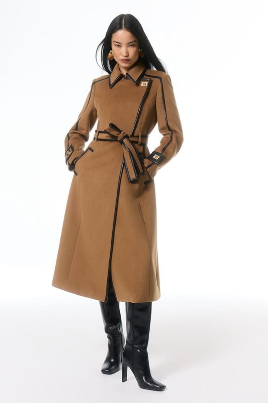 Fall '24: Allow our latest collection of autumn pieces to inspire you for the season ahead. Feel elevated no matter the weather in our midi length coat, made in high quality, thick wool, featuring a fit that flatters the figure and faux leather trims. Wear it over any outfit, whether heading out for dinner or to the office. Wool Blend Faux Leather Trim Belted Tailored Coat High Quality Wool Blend Fabric Flattering Fitted Bodice Straight Hanging Skirt Metallic Clasp Buttons at Collar and Cuffs High, Collared Neckline Belted Waistline Unique, Faux Leather TrimsShop this seasons belted coats and jackets or browse the full collection of coats and jackets now.