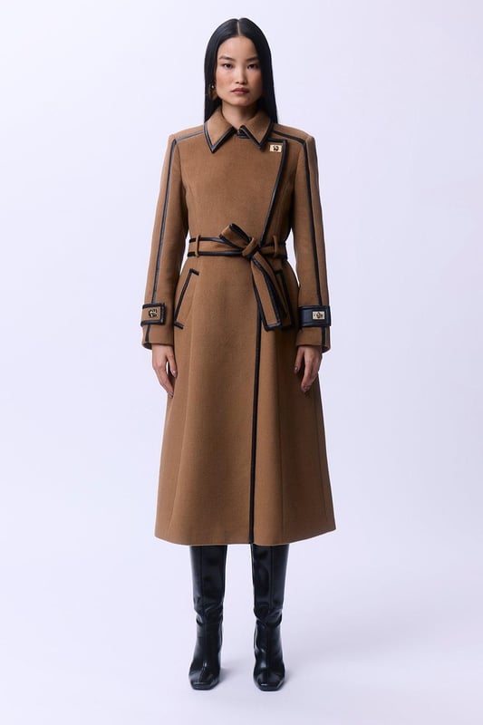 Fall '24: Allow our latest collection of autumn pieces to inspire you for the season ahead. Feel elevated no matter the weather in our midi length coat, made in high quality, thick wool, featuring a fit that flatters the figure and faux leather trims. Wear it over any outfit, whether heading out for dinner or to the office. Wool Blend Faux Leather Trim Belted Tailored Coat High Quality Wool Blend Fabric Flattering Fitted Bodice Straight Hanging Skirt Metallic Clasp Buttons at Collar and Cuffs High, Collared Neckline Belted Waistline Unique, Faux Leather TrimsShop this seasons belted coats and jackets or browse the full collection of coats and jackets now.