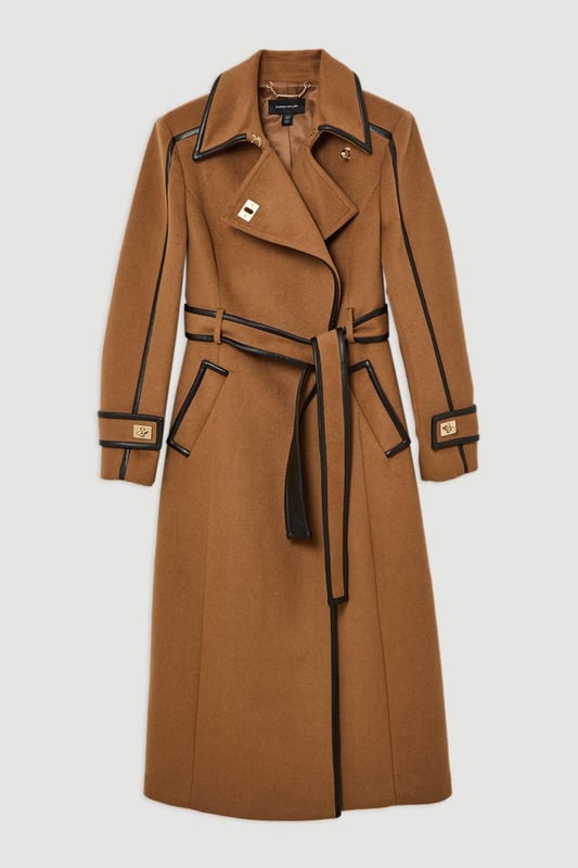 Fall '24: Allow our latest collection of autumn pieces to inspire you for the season ahead. Feel elevated no matter the weather in our midi length coat, made in high quality, thick wool, featuring a fit that flatters the figure and faux leather trims. Wear it over any outfit, whether heading out for dinner or to the office. Wool Blend Faux Leather Trim Belted Tailored Coat High Quality Wool Blend Fabric Flattering Fitted Bodice Straight Hanging Skirt Metallic Clasp Buttons at Collar and Cuffs High, Collared Neckline Belted Waistline Unique, Faux Leather TrimsShop this seasons belted coats and jackets or browse the full collection of coats and jackets now.