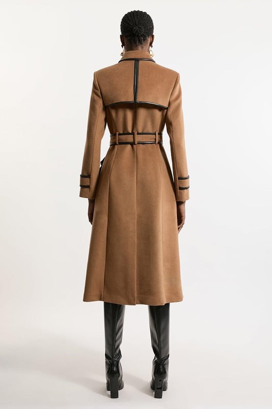 Fall '24: Allow our latest collection of autumn pieces to inspire you for the season ahead. Feel elevated no matter the weather in our midi length coat, made in high quality, thick wool, featuring a fit that flatters the figure and faux leather trims. Wear it over any outfit, whether heading out for dinner or to the office. Wool Blend Faux Leather Trim Belted Tailored Coat High Quality Wool Blend Fabric Flattering Fitted Bodice Straight Hanging Skirt Metallic Clasp Buttons at Collar and Cuffs High, Collared Neckline Belted Waistline Unique, Faux Leather TrimsShop this seasons belted coats and jackets or browse the full collection of coats and jackets now.