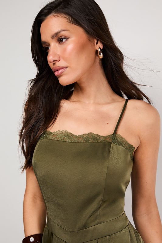 Delicate lace trim along the neckline adds a feminine touch to this satin jumpsuit
        Adjustable strappy design ensures a comfortable, personalised fit
        Elasticated cuffs create a distinctive balloon silhouette for the legs
        Relaxed fit through the body offers effortless movement and comfort
        Petite sizing ensures the perfect proportions for smaller frames
    
    This Warehouse satin jumpsuit combines casual comfort with sophisticated style. The lustrous fabric catches the light beautifully whilst the elasticated cuffs create a fashionable balloon silhouette that's both on-trend and flattering. Perfect for daytime gatherings, style with flat strappy sandals and wooden bangles for a relaxed garden party or family lunch. For cooler evenings, layer with an oversized denim jacket and switch to ankle boots. The versatile design transitions seamlessly from casual brunches to evening drinks - simply add statement earrings and a clutch bag to transform your look. The adjustable straps allow you to customise the fit, making this jumpsuit a wardrobe essential that works hard for your everyday style.