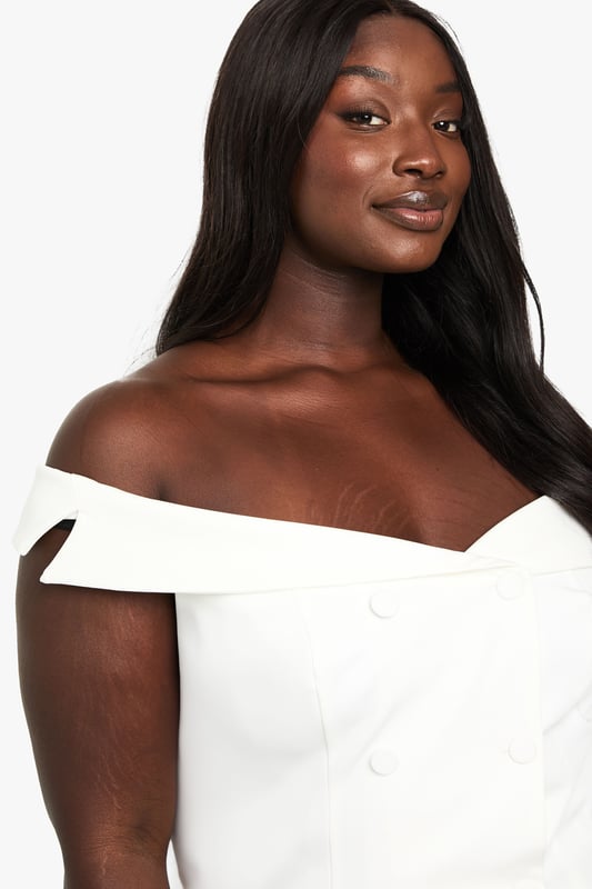 Elegant off-shoulder design with a sweetheart neckline for a flattering silhouette
        Structured bodice with decorative button detailing down the front
        Chic fold-over bardot style neckline that showcases the dcolletage
        Versatile cropped length perfect for high-waisted bottoms
        Tailored fit that accentuates your curves whilst providing comfort
    
    This sophisticated off-shoulder top brings a touch of glamour to your occasion wardrobe. The structured bodice with its elegant button detailing creates a refined look that commands attention at formal gatherings. Style with high-waisted tailored trousers and strappy heels for graduation ceremonies or summer weddings, or pair with a flowing midi skirt for race day elegance. The versatile design works brilliantly with statement jewellery - try layered necklaces or dramatic earrings to complement the clean neckline. For cooler evenings, drape a lightweight blazer over your shoulders without compromising the beautiful bardot detail. This Boohoo piece transitions effortlessly from daytime events to evening soires, making it an essential addition to your occasion collection.
