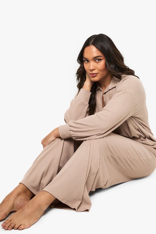 Ribbed texture for added comfort and visual interest
        Collared neckline with open V-front for a relaxed yet polished look
        Wide-leg trousers with flowing silhouette for unrestricted movement
        Long sleeves with comfortable cuffed finish
        Coordinated two-piece set for effortless styling
    
    This sophisticated loungewear set from Boohoo combines comfort with contemporary style. The ribbed collared top features a flattering V-neckline that adds a touch of refinement to your at-home wardrobe, while the wide-leg trousers create a fluid silhouette that moves beautifully with you. Perfect for those lazy Sunday mornings with a coffee and magazine, yet smart enough for impromptu video calls or welcoming unexpected visitors. Style with trainers as seen on our model for quick errands, or swap for plush slippers when embracing total relaxation. The versatile design works wonderfully layered with an oversized cardigan when temperatures drop, or simply on its own for warmer days. This set represents the ultimate balance between comfort and put-together style for the fashion-conscious homebody.