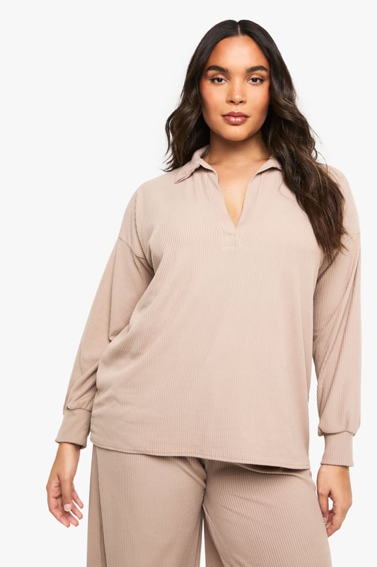 Ribbed texture for added comfort and visual interest
        Collared neckline with open V-front for a relaxed yet polished look
        Wide-leg trousers with flowing silhouette for unrestricted movement
        Long sleeves with comfortable cuffed finish
        Coordinated two-piece set for effortless styling
    
    This sophisticated loungewear set from Boohoo combines comfort with contemporary style. The ribbed collared top features a flattering V-neckline that adds a touch of refinement to your at-home wardrobe, while the wide-leg trousers create a fluid silhouette that moves beautifully with you. Perfect for those lazy Sunday mornings with a coffee and magazine, yet smart enough for impromptu video calls or welcoming unexpected visitors. Style with trainers as seen on our model for quick errands, or swap for plush slippers when embracing total relaxation. The versatile design works wonderfully layered with an oversized cardigan when temperatures drop, or simply on its own for warmer days. This set represents the ultimate balance between comfort and put-together style for the fashion-conscious homebody.