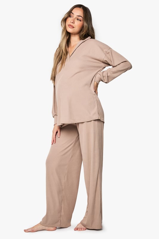 Ribbed maternity loungewear set featuring a collared top and wide-leg trousers
        Relaxed fit design with ample room for growing bump
        Soft ribbed texture for enhanced comfort during rest
        Elegant collar detail adds a refined touch to nightwear
        Wide-leg trousers with comfortable waistband for unrestricted movement
    
    This sophisticated maternity loungewear set combines style and comfort for expectant mothers. The ribbed texture creates a flattering silhouette while providing the stretch needed to accommodate your changing body. The collared neckline adds a touch of elegance to your nightwear collection, making this set perfect for both sleeping and relaxing at home. The wide-leg trousers offer unrestricted movement and comfort, essential during pregnancy. Pair with cosy slippers for the ultimate lounging experience, or throw on a lightweight dressing gown when answering the door. This versatile set will become a staple in your maternity wardrobe, offering the perfect balance of comfort and style during this special time.