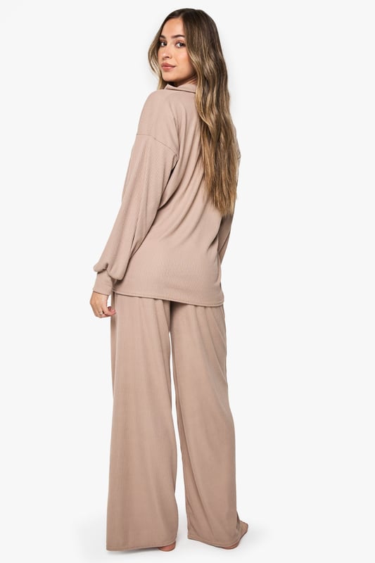 Ribbed maternity loungewear set featuring a collared top and wide-leg trousers
        Relaxed fit design with ample room for growing bump
        Soft ribbed texture for enhanced comfort during rest
        Elegant collar detail adds a refined touch to nightwear
        Wide-leg trousers with comfortable waistband for unrestricted movement
    
    This sophisticated maternity loungewear set combines style and comfort for expectant mothers. The ribbed texture creates a flattering silhouette while providing the stretch needed to accommodate your changing body. The collared neckline adds a touch of elegance to your nightwear collection, making this set perfect for both sleeping and relaxing at home. The wide-leg trousers offer unrestricted movement and comfort, essential during pregnancy. Pair with cosy slippers for the ultimate lounging experience, or throw on a lightweight dressing gown when answering the door. This versatile set will become a staple in your maternity wardrobe, offering the perfect balance of comfort and style during this special time.