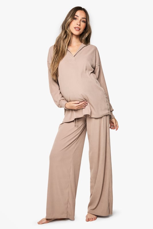 Ribbed maternity loungewear set featuring a collared top and wide-leg trousers
        Relaxed fit design with ample room for growing bump
        Soft ribbed texture for enhanced comfort during rest
        Elegant collar detail adds a refined touch to nightwear
        Wide-leg trousers with comfortable waistband for unrestricted movement
    
    This sophisticated maternity loungewear set combines style and comfort for expectant mothers. The ribbed texture creates a flattering silhouette while providing the stretch needed to accommodate your changing body. The collared neckline adds a touch of elegance to your nightwear collection, making this set perfect for both sleeping and relaxing at home. The wide-leg trousers offer unrestricted movement and comfort, essential during pregnancy. Pair with cosy slippers for the ultimate lounging experience, or throw on a lightweight dressing gown when answering the door. This versatile set will become a staple in your maternity wardrobe, offering the perfect balance of comfort and style during this special time.