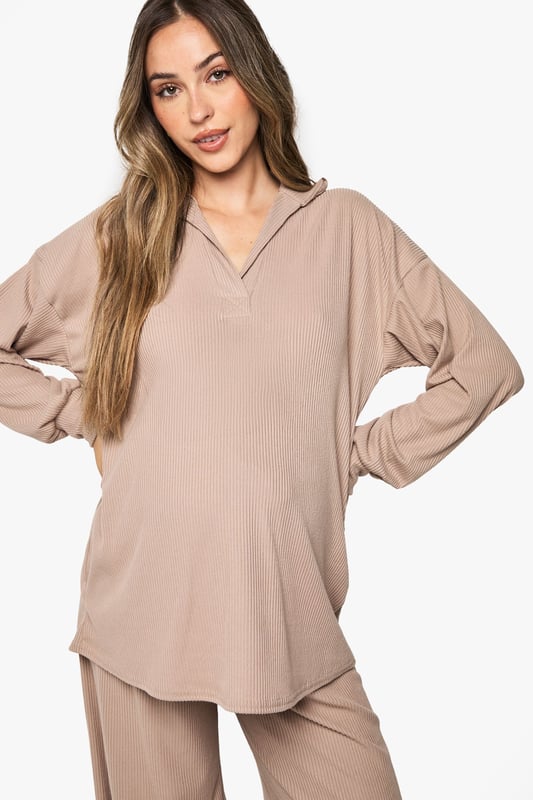 Ribbed maternity loungewear set featuring a collared top and wide-leg trousers
        Relaxed fit design with ample room for growing bump
        Soft ribbed texture for enhanced comfort during rest
        Elegant collar detail adds a refined touch to nightwear
        Wide-leg trousers with comfortable waistband for unrestricted movement
    
    This sophisticated maternity loungewear set combines style and comfort for expectant mothers. The ribbed texture creates a flattering silhouette while providing the stretch needed to accommodate your changing body. The collared neckline adds a touch of elegance to your nightwear collection, making this set perfect for both sleeping and relaxing at home. The wide-leg trousers offer unrestricted movement and comfort, essential during pregnancy. Pair with cosy slippers for the ultimate lounging experience, or throw on a lightweight dressing gown when answering the door. This versatile set will become a staple in your maternity wardrobe, offering the perfect balance of comfort and style during this special time.