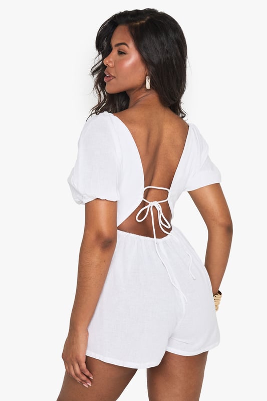 Crafted from a breathable linen mix fabric, perfect for warm-weather styling
        Featuring charming puff sleeves for a feminine, on-trend silhouette
        Flattering V-neckline frames the dcolletage beautifully
        Open back design with delicate tie detail adds a flirty touch
        Relaxed fit with a defined waistline creates a balanced, figure-enhancing shape
    
    This linen mix playsuit from Boohoo combines comfort with effortless style for your casual wardrobe. The puff sleeves add a touch of romance while the V-neckline creates a flattering frame. The open back with tie detail offers a subtle glimpse of skin, perfect for sunny days out. Style with minimal jewellery as seen on our model - think statement earrings and a simple bracelet - and pair with flat sandals for daytime gatherings or family brunches. For a more polished look, add espadrille wedges and a woven clutch. The versatile design works brilliantly for garden parties, seaside holidays or casual weekend outings when you want to look put-together without trying too hard.