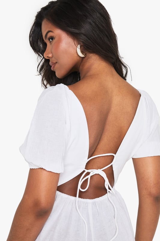 Crafted from a breathable linen mix fabric, perfect for warm-weather styling
        Featuring charming puff sleeves for a feminine, on-trend silhouette
        Flattering V-neckline frames the dcolletage beautifully
        Open back design with delicate tie detail adds a flirty touch
        Relaxed fit with a defined waistline creates a balanced, figure-enhancing shape
    
    This linen mix playsuit from Boohoo combines comfort with effortless style for your casual wardrobe. The puff sleeves add a touch of romance while the V-neckline creates a flattering frame. The open back with tie detail offers a subtle glimpse of skin, perfect for sunny days out. Style with minimal jewellery as seen on our model - think statement earrings and a simple bracelet - and pair with flat sandals for daytime gatherings or family brunches. For a more polished look, add espadrille wedges and a woven clutch. The versatile design works brilliantly for garden parties, seaside holidays or casual weekend outings when you want to look put-together without trying too hard.
