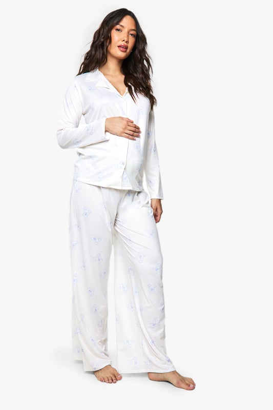 Maternity Bear Print Shirt & Trouser PJ Set Specially designed maternity pyjama set featuring adorable bear print details
Button-through top with relaxed fit to accommodate your growing bump
Long sleeves for extra warmth and comfort during night-time
Wide-leg trousers with gentle elasticated waistband for maximum comfort
Soft, breathable fabric ideal for all stages of pregnancy
Drift off to dreamland in absolute comfort with this charming maternity pyjama set from Boohoo. The relaxed button-through top is thoughtfully designed to grow with you throughout your pregnancy journey, whilst the cute bear print adds a playful touch to your nightwear collection. The wide-leg trousers offer unrestricted movement and feature a gentle waistband that sits comfortably below or over your bump. Perfect for lounging at home on lazy Sunday mornings or for a cosy night's sleep, this set combines practicality with style. Layer with a soft dressing gown and fluffy slippers on chillier evenings for the ultimate in night-time comfort. A must-have addition to your maternity wardrobe that doesn't compromise on style or comfort.