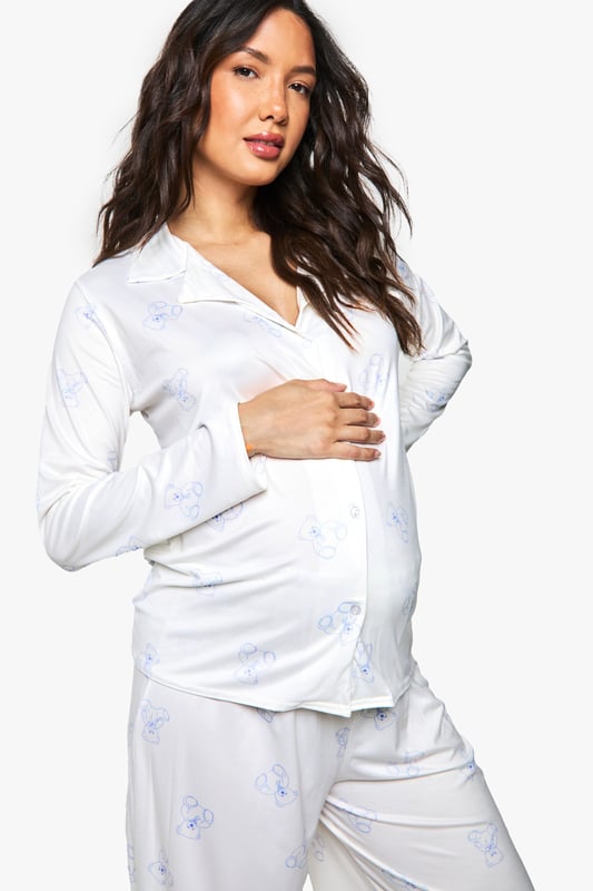 Maternity Bear Print Shirt & Trouser PJ Set Specially designed maternity pyjama set featuring adorable bear print details
Button-through top with relaxed fit to accommodate your growing bump
Long sleeves for extra warmth and comfort during night-time
Wide-leg trousers with gentle elasticated waistband for maximum comfort
Soft, breathable fabric ideal for all stages of pregnancy
Drift off to dreamland in absolute comfort with this charming maternity pyjama set from Boohoo. The relaxed button-through top is thoughtfully designed to grow with you throughout your pregnancy journey, whilst the cute bear print adds a playful touch to your nightwear collection. The wide-leg trousers offer unrestricted movement and feature a gentle waistband that sits comfortably below or over your bump. Perfect for lounging at home on lazy Sunday mornings or for a cosy night's sleep, this set combines practicality with style. Layer with a soft dressing gown and fluffy slippers on chillier evenings for the ultimate in night-time comfort. A must-have addition to your maternity wardrobe that doesn't compromise on style or comfort.