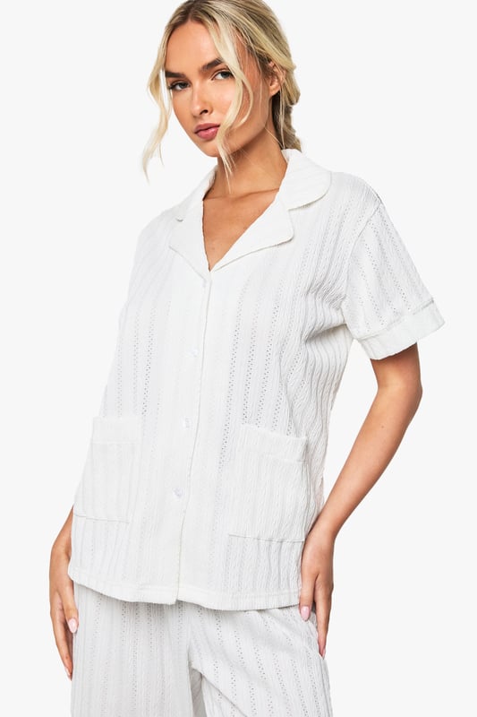 Elegant pointelle knitted fabric with delicate textured pattern throughout
        Classic collared shirt design with short sleeves for comfort
        Relaxed fit trousers with wide-leg silhouette for effortless movement
        Practical front pockets on the shirt for added functionality
        Coordinated two-piece set designed specifically for bridal occasions
    
    This sophisticated Pointelle Short Sleeve Shirt and Trouser Set from Boohoo offers the perfect balance of comfort and style for your special bridal moments. The textured knitted fabric creates a subtle yet distinctive pattern that catches the light beautifully, whilst the classic shirt design with its neat collar presents a refined silhouette. The wide-leg trousers flow gracefully with every movement, creating an air of relaxed elegance. Perfect for bridal preparation photos or post-ceremony relaxation, this set can be styled with delicate jewellery and soft slippers for a morning-of-the-wedding look. Alternatively, pair with elegant flat sandals and a loose braid for a honeymoon breakfast ensemble that radiates newlywed bliss. The versatile design ensures you'll treasure this set long after your wedding celebrations.