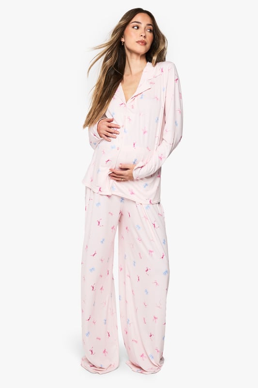 Maternity pyjama set featuring a charming bow print pattern throughout
        Classic button-through shirt design with notched collar for timeless nightwear style
        Relaxed fit with generous cut to accommodate your growing bump comfortably
        Full-length trousers with wide legs for unrestricted movement during sleep
        Long sleeves provide extra warmth and coverage for cooler evenings
    
    Drift into dreamland in absolute comfort with this delightful maternity pyjama set from Boohoo. Designed specifically for mums-to-be, this set combines practicality with style through its relaxed silhouette that grows with you throughout your pregnancy journey. The soft fabric feels gentle against sensitive skin, whilst the classic button-through design makes night feeds and bathroom breaks hassle-free. The wide-leg trousers offer ample room for movement, perfect for finding that elusive comfortable sleeping position. Pair with fluffy slippers and a warm dressing gown for those midnight kitchen trips, or simply lounge around on weekend mornings with a cup of tea and your favourite book. This set strikes the perfect balance between functionality and fashion, ensuring you look and feel your best during this special time.
