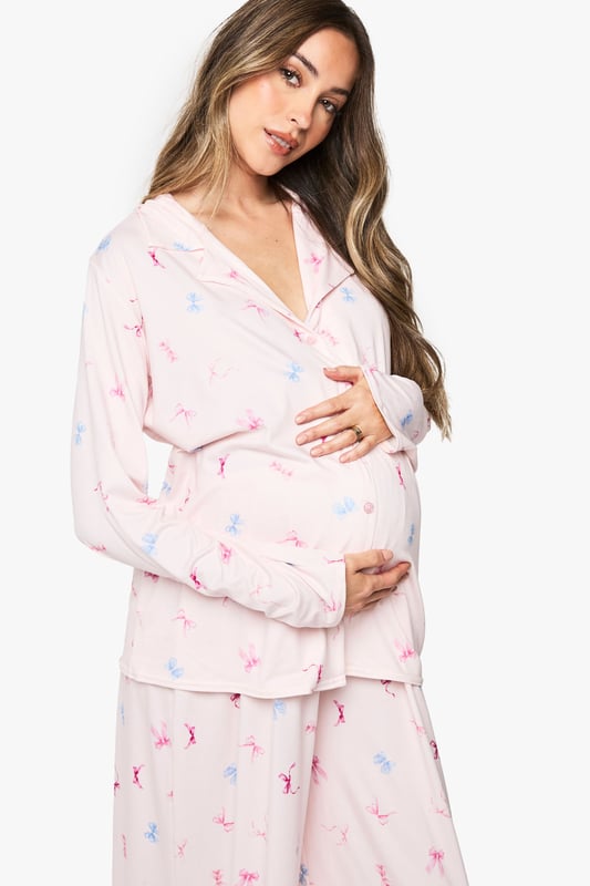 Maternity pyjama set featuring a charming bow print pattern throughout
        Classic button-through shirt design with notched collar for timeless nightwear style
        Relaxed fit with generous cut to accommodate your growing bump comfortably
        Full-length trousers with wide legs for unrestricted movement during sleep
        Long sleeves provide extra warmth and coverage for cooler evenings
    
    Drift into dreamland in absolute comfort with this delightful maternity pyjama set from Boohoo. Designed specifically for mums-to-be, this set combines practicality with style through its relaxed silhouette that grows with you throughout your pregnancy journey. The soft fabric feels gentle against sensitive skin, whilst the classic button-through design makes night feeds and bathroom breaks hassle-free. The wide-leg trousers offer ample room for movement, perfect for finding that elusive comfortable sleeping position. Pair with fluffy slippers and a warm dressing gown for those midnight kitchen trips, or simply lounge around on weekend mornings with a cup of tea and your favourite book. This set strikes the perfect balance between functionality and fashion, ensuring you look and feel your best during this special time.