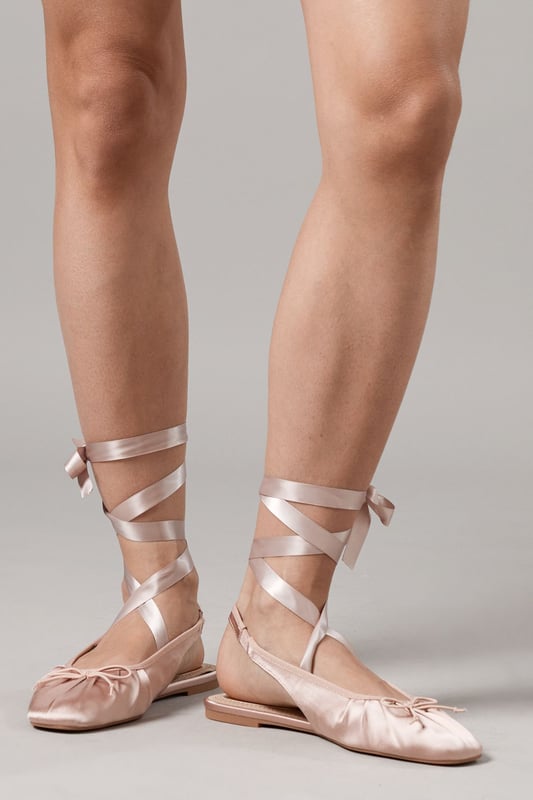 Luxurious satin ballet pumps with elegant ankle tie detail
        Comfortable flat heel measuring between 0-2cm for all-day wear
        Delicate slingback design with secure ribbon ties
        Soft gathered detail at the toe for a feminine finish
        Versatile pointed toe silhouette perfect for both casual and formal styling
    
    The Faith Lia Ballet Pumps combine timeless elegance with contemporary styling. These sophisticated flats feature sumptuous satin fabric that catches the light beautifully, whilst the ankle-wrap ribbons create a graceful, balletic effect that flatters the leg. Style them as shown with denim for an effortless daytime look, or pair with flowing midi dresses for garden parties and summer weddings. The pointed toe elongates the silhouette, making these an excellent choice for formal occasions when heels aren't practical. The flat design offers comfort without compromising on style, allowing you to dance the night away at special events or navigate cobbled streets during city breaks. These versatile pumps transition seamlessly from day to evening, making them an essential addition to your footwear collection.