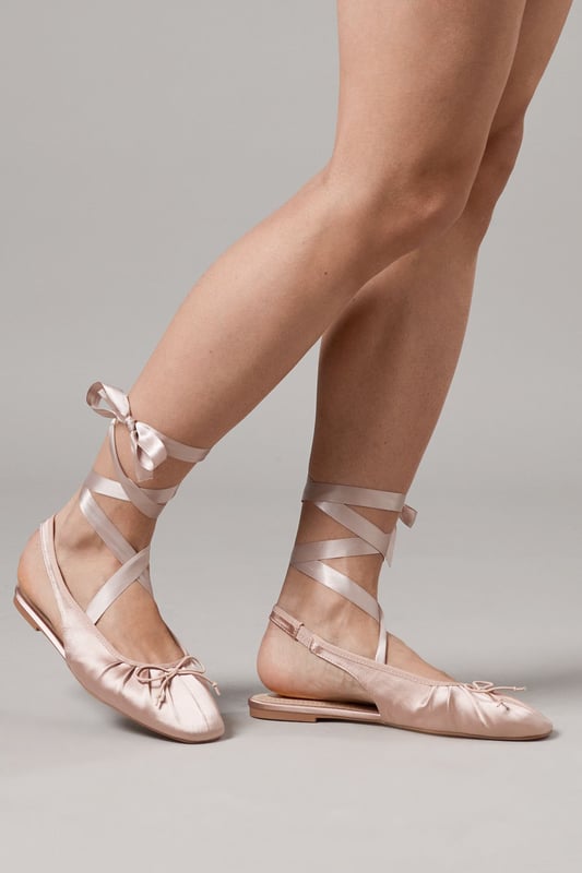Luxurious satin ballet pumps with elegant ankle tie detail
        Comfortable flat heel measuring between 0-2cm for all-day wear
        Delicate slingback design with secure ribbon ties
        Soft gathered detail at the toe for a feminine finish
        Versatile pointed toe silhouette perfect for both casual and formal styling
    
    The Faith Lia Ballet Pumps combine timeless elegance with contemporary styling. These sophisticated flats feature sumptuous satin fabric that catches the light beautifully, whilst the ankle-wrap ribbons create a graceful, balletic effect that flatters the leg. Style them as shown with denim for an effortless daytime look, or pair with flowing midi dresses for garden parties and summer weddings. The pointed toe elongates the silhouette, making these an excellent choice for formal occasions when heels aren't practical. The flat design offers comfort without compromising on style, allowing you to dance the night away at special events or navigate cobbled streets during city breaks. These versatile pumps transition seamlessly from day to evening, making them an essential addition to your footwear collection.