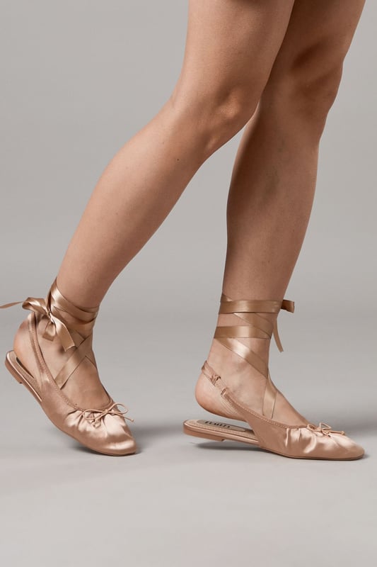 Luxurious satin ballet pumps with elegant ankle tie detail
        Comfortable flat heel measuring between 0-2cm for all-day wear
        Delicate slingback design with secure ribbon ties
        Soft gathered detail at the toe for a feminine finish
        Versatile pointed toe silhouette perfect for both casual and formal styling
    
    The Faith Lia Ballet Pumps combine timeless elegance with contemporary styling. These sophisticated flats feature sumptuous satin fabric that catches the light beautifully, whilst the ankle-wrap ribbons create a graceful, balletic effect that flatters the leg. Style them as shown with denim for an effortless daytime look, or pair with flowing midi dresses for garden parties and summer weddings. The pointed toe elongates the silhouette, making these an excellent choice for formal occasions when heels aren't practical. The flat design offers comfort without compromising on style, allowing you to dance the night away at special events or navigate cobbled streets during city breaks. These versatile pumps transition seamlessly from day to evening, making them an essential addition to your footwear collection.
