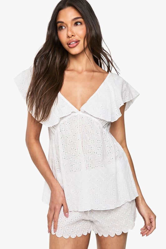Bridal Broderie Anglaise Frill Cami Top & Shorts Pyjama Set Delicate broderie anglaise fabric with intricate eyelet detailing throughout
Feminine cami top with romantic V-neckline and charming frill overlay
Relaxed fit design for ultimate comfort during your special night
Matching shorts with scalloped hem for a coordinated bridal look
Soft woven fabric that feels gentle against the skin
Make your wedding night as special as your big day with this enchanting broderie anglaise pyjama set from Boohoo. The delicate eyelet detailing and feminine frills create a romantic aesthetic that's perfect for your bridal celebration. The flattering V-neckline and loose-fitting silhouette ensure both style and comfort as you unwind after your wedding festivities. Style with tousled hair and minimal jewellery for an effortlessly beautiful bridal nightwear look. This charming two-piece set strikes the perfect balance between comfort and elegance, making it an ideal addition to your wedding trousseau. The scalloped hem shorts complement the frill-detailed cami top beautifully, creating a cohesive set you'll treasure beyond your wedding night.