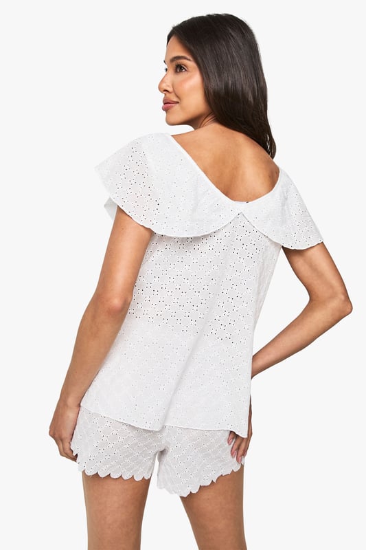 Bridal Broderie Anglaise Frill Cami Top & Shorts Pyjama Set Delicate broderie anglaise fabric with intricate eyelet detailing throughout
Feminine cami top with romantic V-neckline and charming frill overlay
Relaxed fit design for ultimate comfort during your special night
Matching shorts with scalloped hem for a coordinated bridal look
Soft woven fabric that feels gentle against the skin
Make your wedding night as special as your big day with this enchanting broderie anglaise pyjama set from Boohoo. The delicate eyelet detailing and feminine frills create a romantic aesthetic that's perfect for your bridal celebration. The flattering V-neckline and loose-fitting silhouette ensure both style and comfort as you unwind after your wedding festivities. Style with tousled hair and minimal jewellery for an effortlessly beautiful bridal nightwear look. This charming two-piece set strikes the perfect balance between comfort and elegance, making it an ideal addition to your wedding trousseau. The scalloped hem shorts complement the frill-detailed cami top beautifully, creating a cohesive set you'll treasure beyond your wedding night.